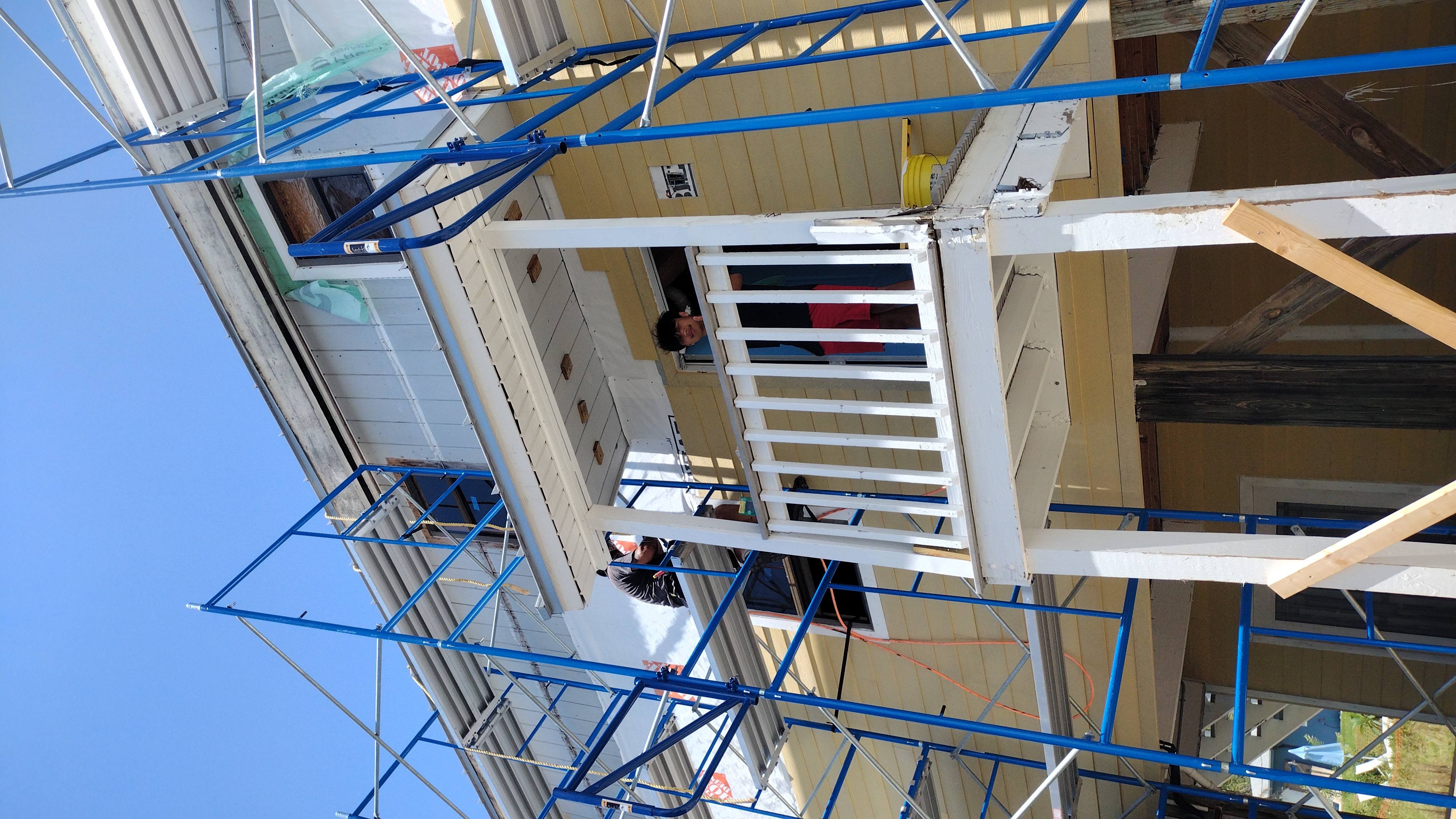 Crew fitting Hardie board trim on the upper balcony — Bell Engineering & Construction