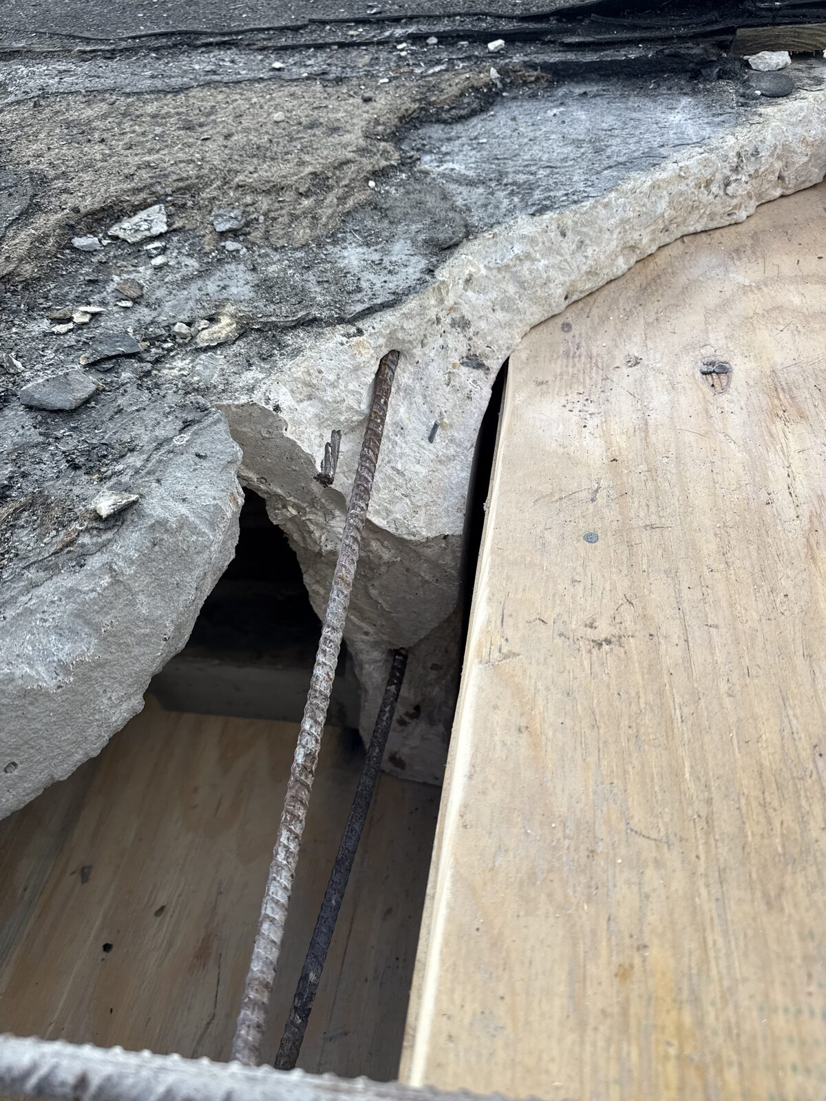 Corroded reinforcing steel exposed in a spalled concrete carport beam at an HOA community in Royal Palm Beach