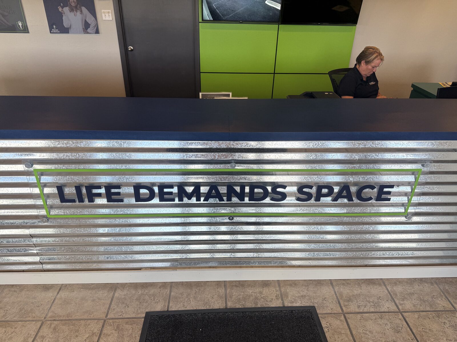 Detail of the counter's corrugated galvanized customer face with the signage panel remounted — Bell Engineering & Construction