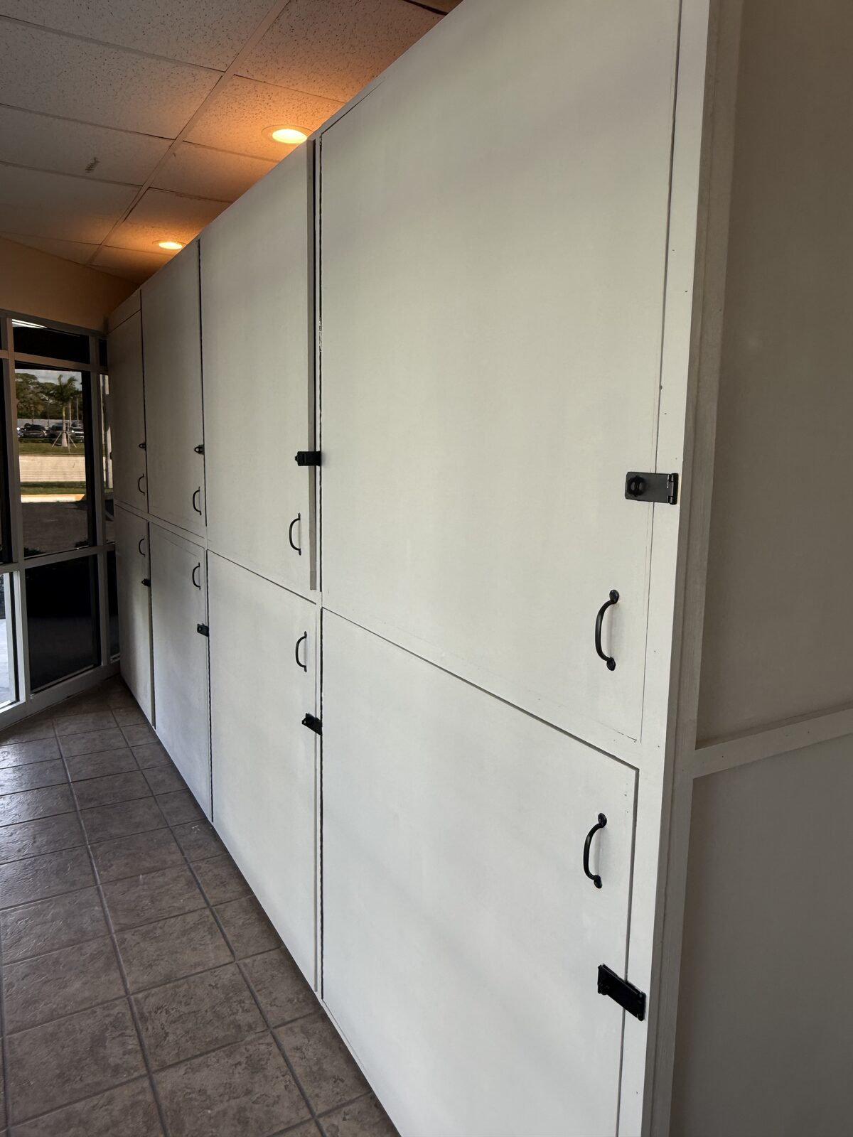 The completed run of site-built storage lockers along the lobby wall — Bell Engineering & Construction