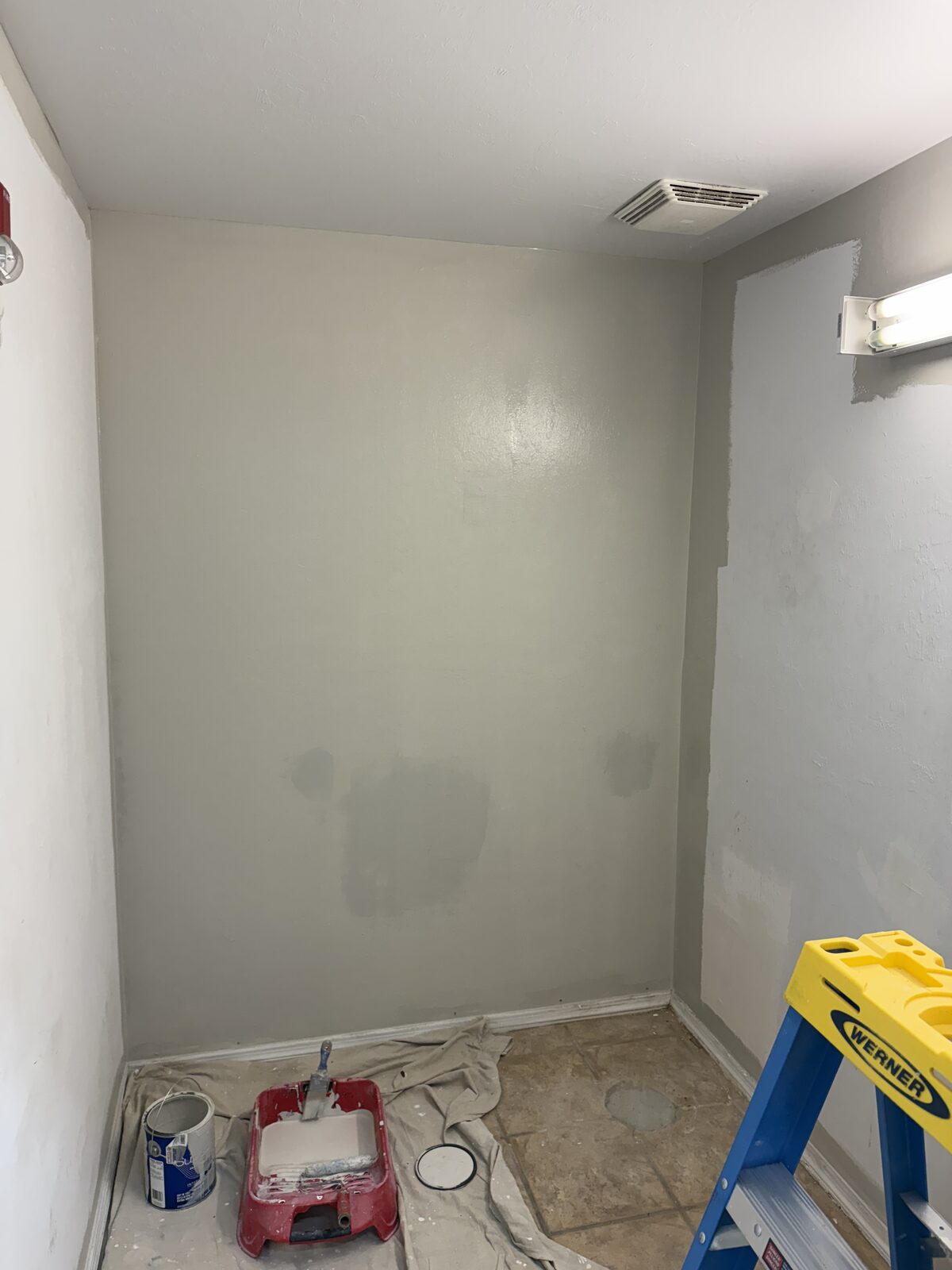 Repainted office corner with patched areas blended in, tools staged on the drop cloth — Bell Engineering & Construction