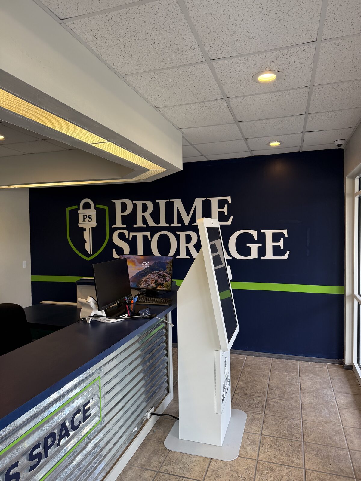 Completed leasing counter and self-service kiosk against the repainted feature wall — Bell Engineering & Construction