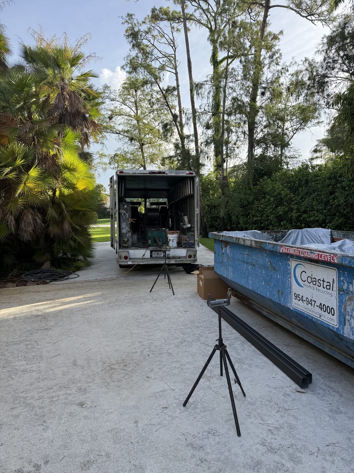 Grumman step van set up on a Wellington FL driveway with gutter run-out stands and a finished dark downspout length staged alongside a waste container