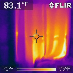 FLIR infrared capture of an interior wall reading 83.1 degrees Fahrenheit on a 71 to 95 degree scale, showing warm vertical stripes in the wall cavity
