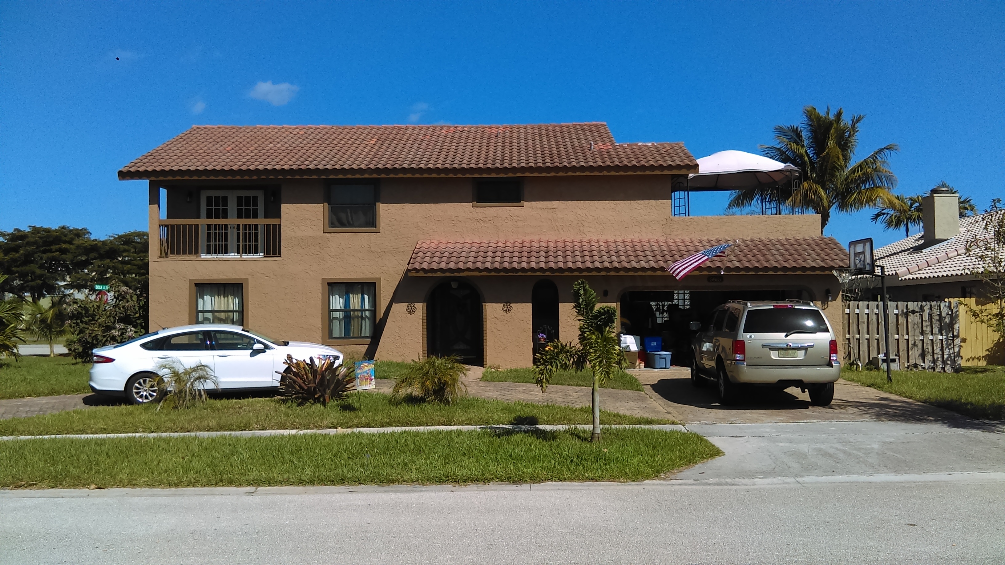 Two-storey South Florida stucco house with a barrel-tile roof, second-floor balcony and arched entry — the subject of a 2017 residential energy audit