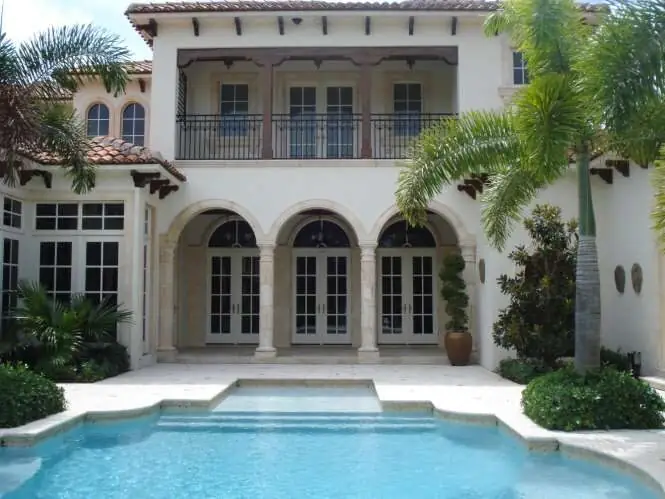 Mediterranean Palm Beach estate with an arched loggia over a turquoise pool