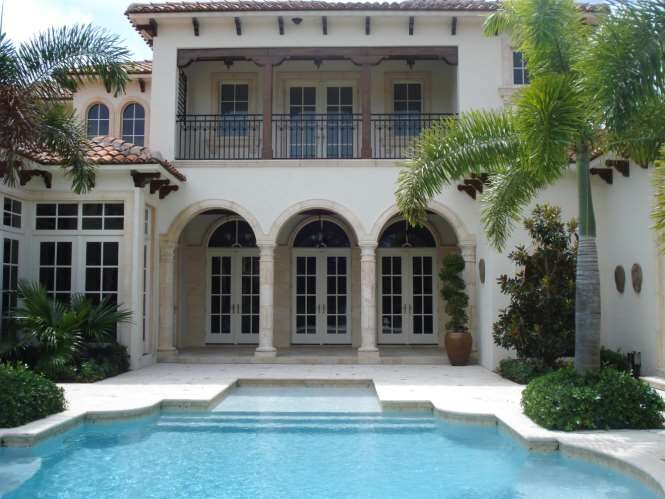 Mediterranean Palm Beach estate with an arched loggia over a turquoise pool