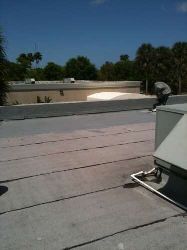 Bell crew member preparing a flat estate roof for a protective coating in Palm Beach County