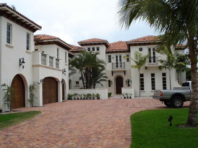 Grand two-wing Mediterranean estate with a paver motor court and royal palms