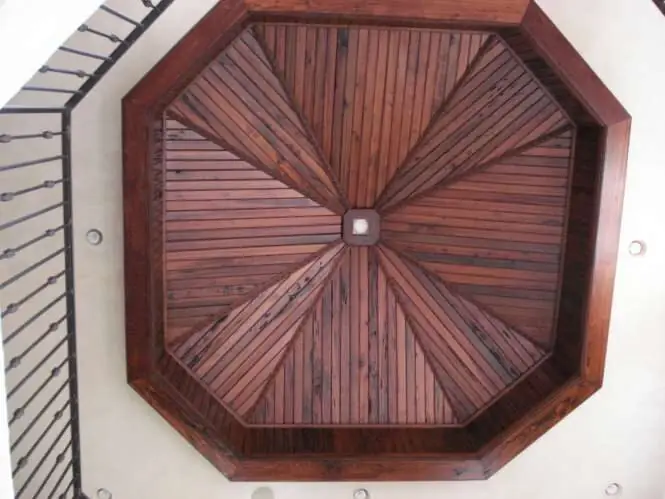 Octagonal reclaimed-wood dome ceiling above a wrought-iron stair rail