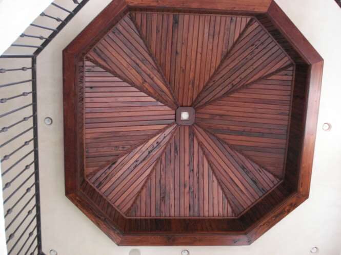 Octagonal reclaimed-wood dome ceiling above a wrought-iron stair rail