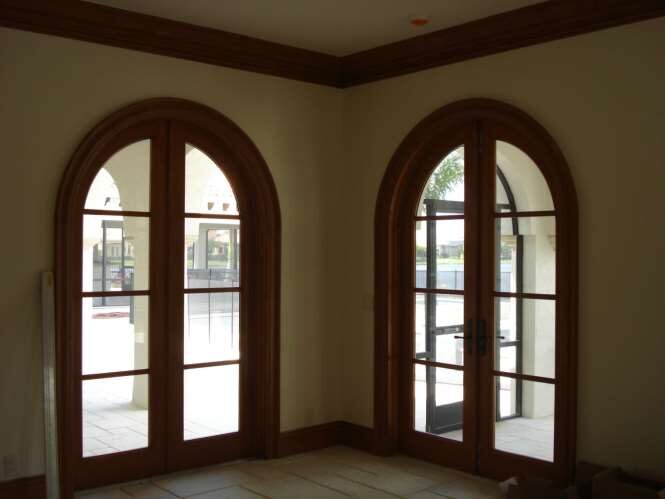 Interior corner with twin arched wood-framed French doors looking out to the pool courtyard