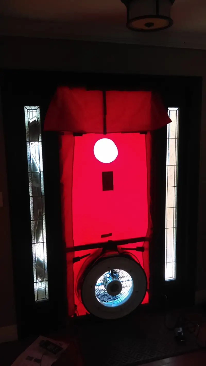 Blower-door test sealed into a front doorway during a residential energy audit